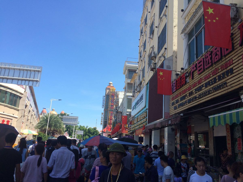 人头涌涌的口岸边的街道,五星红旗