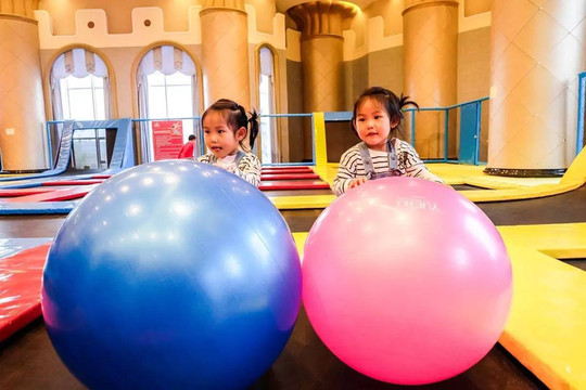 原来这里的蹦床太刺激了,小朋友意犹未尽的玩耍著,开心的抱起瑜伽球东