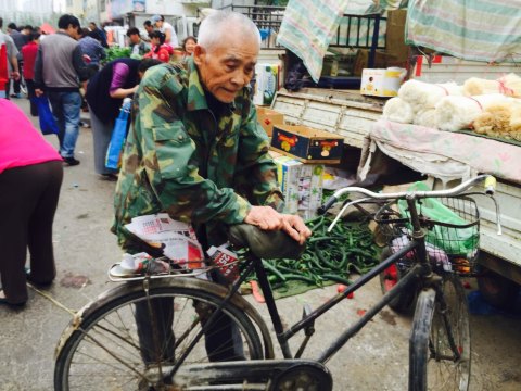 扶自行车买菜的老人.行动缓慢,这个姿势保持很久了 珠江桥菜场附近